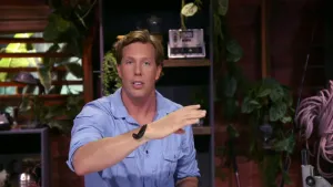 Een foto van presentator Freek met een bloedzuiger op zijn arm. Deze bloedzuiger ziet er uit als een grote zwarte slak.