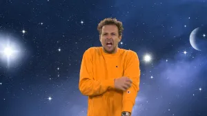 Een foto van Tim in een oranje trui. Hij krabt met zijn rechterhand op zijn linkerarm en heeft zijn mond wijdopen op de foto. Op de achtergrond is een tekening van een paarsblauw heelal te zien met oplichtende sterren en rechts een stukje van een planeet.