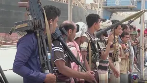 Een foto van mannen en jongemannen die buiten naast elkaar staan met zware wapens in hun handen.