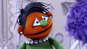 Een foto van een oranje pop die met een paarse pop aan het praten is in het museum van gewone dingen.