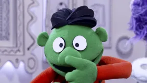 Een foto van een groene pop die in het 'museum van gewone dingen' staat.