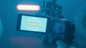 Een foto van een wapen voor het spelen van een game. Aan de linkerkant van het wapen hangt een beeldscherm, waarop de tekst "Lekker" in de vorm van een ster tegen een blauwe achtergrond te lezen is. Dit is te lezen, omdat er net een score behaald is. 