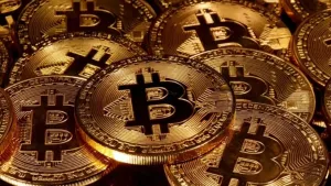 Een foto van gouden munten. Op die munten staat de letter B met twee strepen van boven naar beneden erop. Dat is het teken van de Bitcoin.