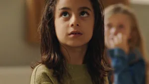 Een foto van een jong meisje. Ze heet Berith en kijkt omhoog. Ze ziet er wat angstig uit.