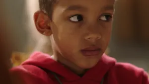 Een foto van een jongetje. Hij heet Jairo. Je ziet zijn gezicht van dichtbij. Hij kijkt angstig. 