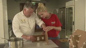 Een foto van presentator Janouk die met bakker Robèrt een huisje van koek aan het maken zijn.