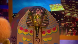 Een foto van een sarcofaag gevonden door pop Indianna Jansen. Een sarcofaag is een doodskist uit het oude Egypte waar de leiders, farao's, in begraven werden. Er zit een hoofd van een farao als versiering op de kist en gele, rode en blauwe versieringen. 