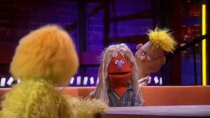 Een foto van drie poppen, een geelharige presentator links, Meneer roeven op een bank in het midden en kapper Antoine, die achter de bank loopt. Meneer Roeven heeft lang, dik haar dat 30 jaar niet geknipt is en kijkt bang. Hij is bang voor de kapper.