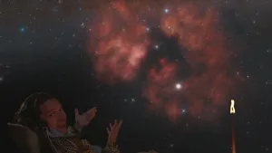 Een foto van presentator Pascal die in het donker buiten zit. Boven hem is het heelal te zien.