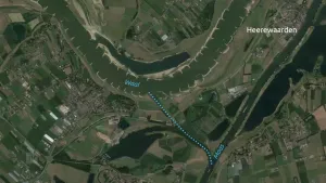 Een foto vanuit de lucht genomen, naar beneden. Je ziet de rivieren de Waal en de Maas. Daartussen loopt een stippellijntje op de foto. Rechtsboven in beeld staat de tekst Heerewaarden bij een dorpje.