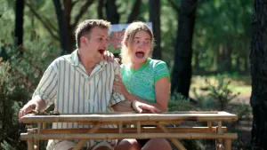 Een foto van Jurre en Emma die buiten zitten aan een houten tafel. Ze schrikken allebei heel erg, maar je ziet niet waarom.