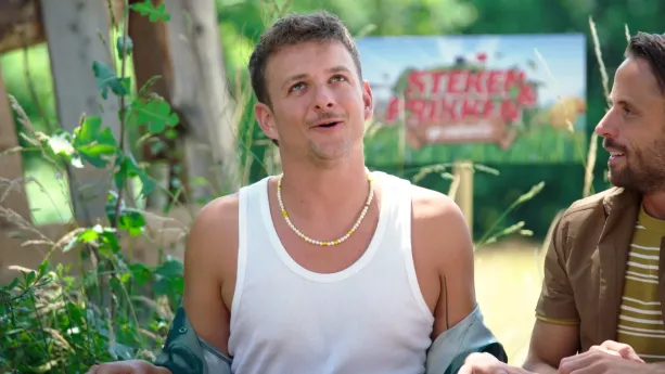 Een foto van Jurre die aan het praten is. Hij kijkt wat omhoog. Naast hem staat een man die naar Jurre kijkt. 