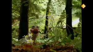 Een foto van Piertje in het bos. Op de voorgrond zie je wat wilde bloemen. 