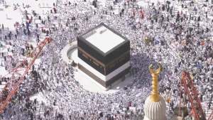 Een foto van bovenaf genomen van de Kaäba, een kubus in de grote moskee in Mekka. Tijdens de hadj, een bedevaartstocht die de moslims ondernemen, lopen ze zeven keer rond de Kaäba. Op de foto staan veel moslims in witte kleding rond de Kaäba.
