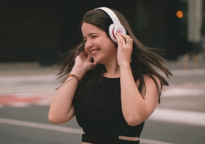 Foto van een vrouw met een witte koptelefoon.