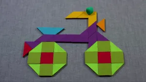 Foto van een schematisch gemaakt kinderfietsje, bestaande uit platte houten vormpjes zoals vierkantjes.