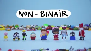 Een foto met negen speelgoedpoppetjes op een rij van de merken Playmobil, Little People, Duplo en Poopsie Cutie. Boven de poppetjes staat "Non-Binair". Op de achtergrond liggen meer speelgoedfiguren en vooraan is ook nog net speelgoed zichtbaar.
