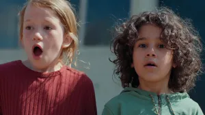 Een foto van Anna en Saïd die geschrokken kijken naar iets dat gebeurd of gebeurd is achter de camera. Anna heeft haar mond wijd open. En Saïd heeft zijn mond ook iets open. Beiden hebben hun wenkbrauwen opgetrokken en kijken met grote ogen.