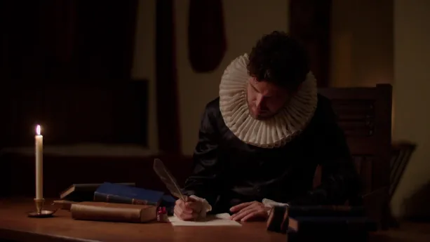 Een foto van Hugo de Groot die achter een bureau met een veer op een vel papier zit te schrijven. Op het bureau staat een kaars en liggen boeken. Hugo heeft een witte kraag, die molensteenkraag wordt genoemd, om zijn hals.