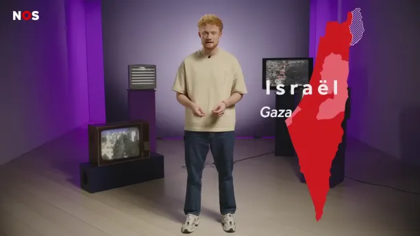 Een foto van een presentator in een ruimte waar drie ouderwetse televisies op de achtergrond te zien zijn. Rechts van de presentator is een kaart van het land Israël zichtbaar, met daarin het gebied Gaza weergegeven.