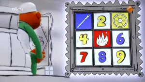 Een foto van een grijze schilderijlijst met plaatjes erin van cijfers en dingen. Het is een memoryspel dat wordt gespeeld door een pop in een grote stoel links. Er zijn nog maar drie van de negen plaatjes omgedraaid: een vijl, een wiel en een vuur.  