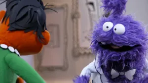 Een foto van een paarse pop die aan het praten is met een rode pop in het museum van gewone dingen.