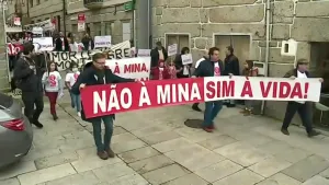Een foto van demonstranten die met spandoeken en borden lopen met buitenlandse teksten erop.