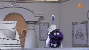 Een foto van een pop met een paarse vacht, een witte hoge hoed en een wit strikje om zijn hals. Op de rug van de pop steekt een witte akoestische gitaar omhoog. Rechts hangt een schilderijlijst met een getekende zwarte fiets op het schilderij.