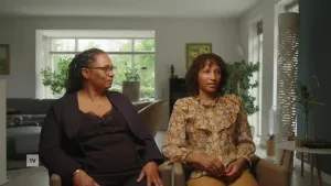 Een foto van een moeder en haar dochter die in de huiskamer zitten.