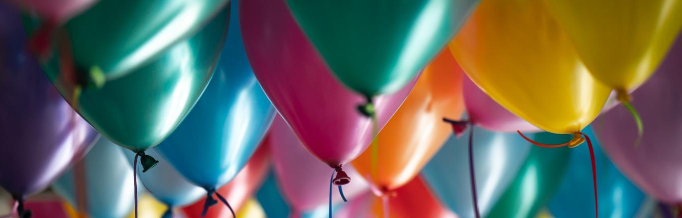 Gekleurde ballonnen met touwtjes, photo by Adi Goldstein on Unsplash