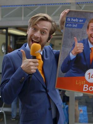 Man staat naast verkiezingsposter en steekt duim op