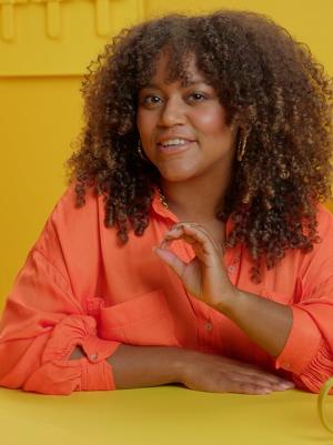 Quinty Misiedjan achter geel bureau