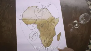 Een foto van een tekening op een tafel. De tekening is een landkaart van Afrika met daarop Engelse teksten geschreven. Een hand wijst naar die tekening. 