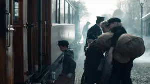 Een foto van een gezin die een trein willen instappen. Een jongetje stapt als eerste in de trein. De vader staat achter hen en houdt een grote zak vast. 