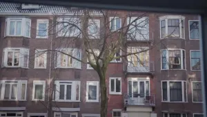 Een foto van een al wat ouder appartementencomplex van enkele verdiepingen hoog.