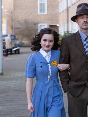 acteurs lopen op straat die Anne Frank en Otto Frank spelen
