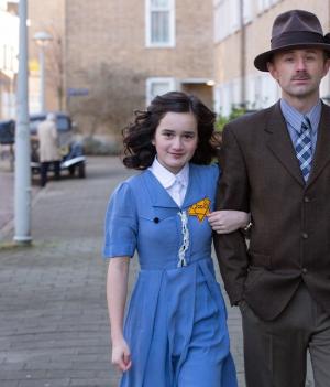 acteurs lopen op straat die Anne Frank en Otto Frank spelen