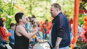 Foto van man en vrouw die buiten staan op de Vrijmarkt, op de achtergrond vele mensen die erlangs lopen.