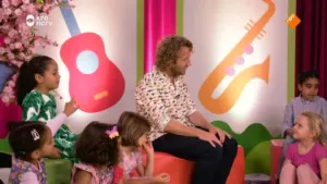 Foto van studio waarin kinderen zitten en een man.