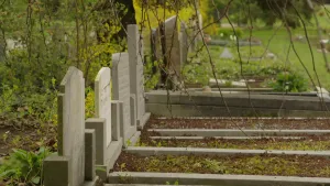 Een foto van een rij grafstenen op een begraafplaats. De foto is van de zijkant genomen, zodat de tekst op de grafstenen niet te lezen is.