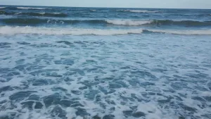 Een foto aan het strand in Costa-Rica. Alleen schuimend water en golven zijn zichtbaar.