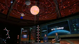 Een foto van presentatoren in de 'Earth challenge' studio. Boven hun is een met de computer gemaakte zon en planeten te zien.