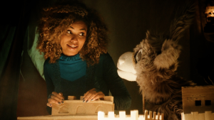 Een foto van een vrouw die naar ezel Chiel kijkt terwijl ze op een kleine versie leunt van een kasteelmuur.