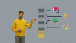 Een foto van een presentator die een overzicht aanwijst over te besteden geld. Twintig grijze balkjes zijn verbonden met plaatjes van een huis, een gloeilamp, kleding en een bord met eten. Zeven gele balkjes tonen het geld dat nog uitgegeven kan worden.