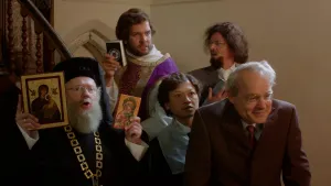 Een foto van vijf mensen die voor een houten trap staan en die allemaal de bij hun christelijke stoming passende kleding aanhebben. Ook hebben twee mensen gebedsboeken vast en heeft één persoon twee iconen in de vorm van kleine schilderijen vast.