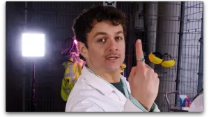 Een foto van presentator Jurre die zijn wijsvinger omhoog houdt voor de camera. Jurre heeft een ring met een smaragdgroene steen om.