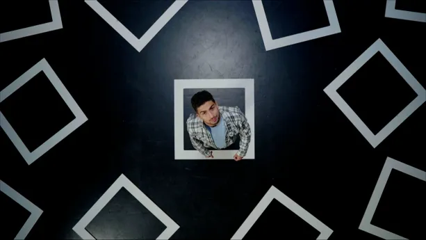 Een foto van presentator Nizar die in een vierkant op de grond staat wat een hokje moet voorstellen. In de foto zijn meerdere hokjes te zien.