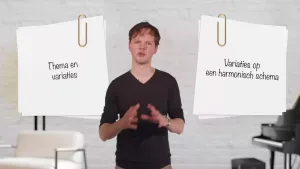Een foto van een presentator met links en rechts van de presentator een wit vel papier met een paperclip eraan zichtbaar. Op het papier links staat de tekst "Thema en variaties", op het papier rechts staat de tekst "Variaties op een harmonisch schema".