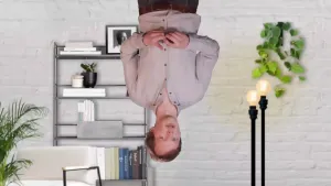 Een foto van een presentator die op zijn kop zichtbaar is, vanaf zijn middel tot zijn hoofd. Op de achtergrond is een woonkamer zichtbaar, die niet op zijn kop staat. Dit komt verwarrend over en sluit aan op het onderwerp muzikale desoriëntatie.