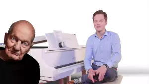 Een foto van een presentator die achter een witte piano zit. Links van de presentator is een animatie zichtbaar van Simeon ten Holt, de bekendste Nederlandse minimal music-maker. De achtergrond is geheel wit van kleur.